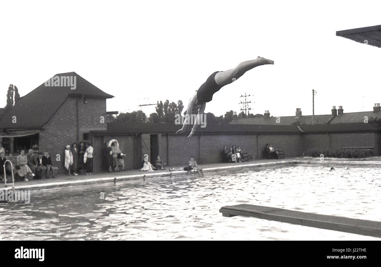 Années 1950, les femmes à partir d'une plate-forme de plongée ou la plongée dans une piscine extérieure, England, UK. Banque D'Images