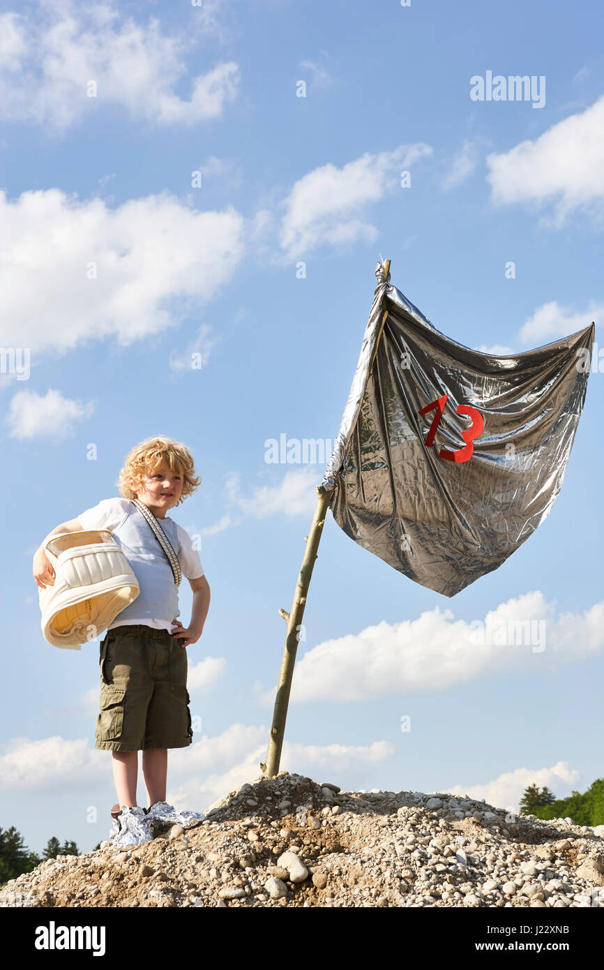 Petit garçon debout sur une colline à l'atterrissage de lune Banque D'Images