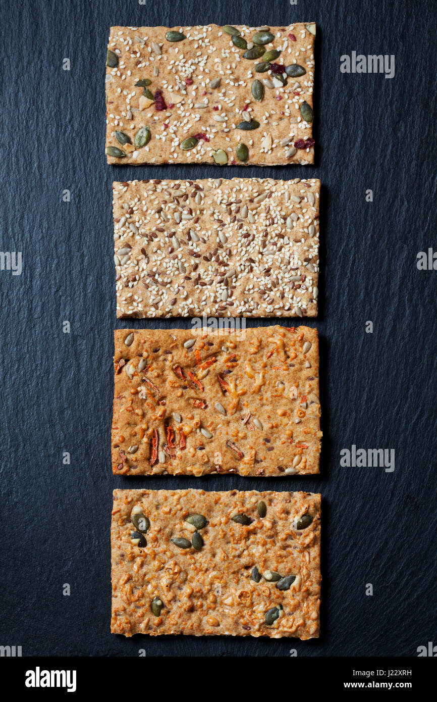 Rangée de quatre différentes tranches de crispbreads grain sur ardoise Banque D'Images