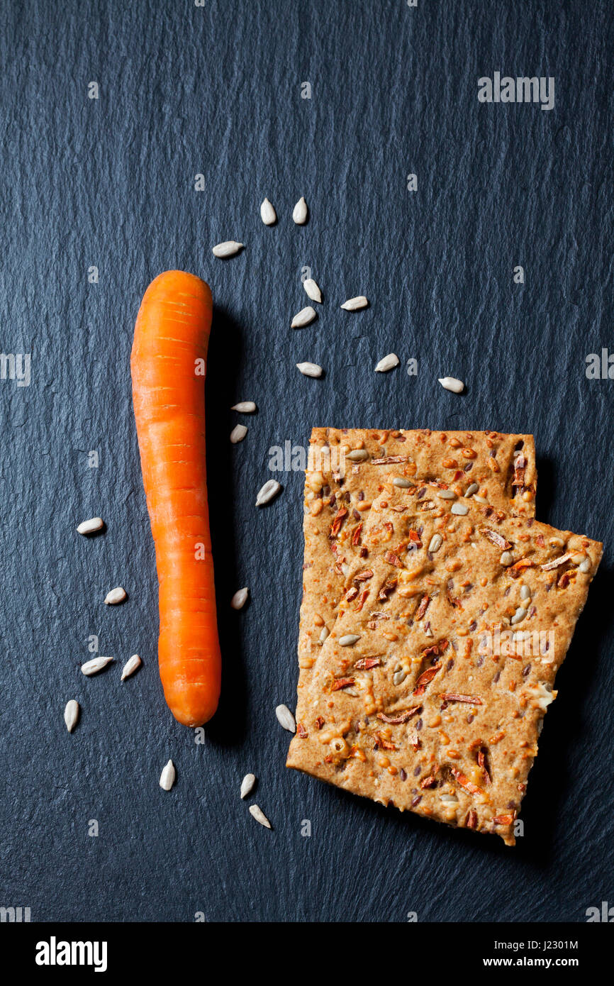 Deux tranches de pain croustillant à la carotte et graines de tournesol sur ardoise Banque D'Images