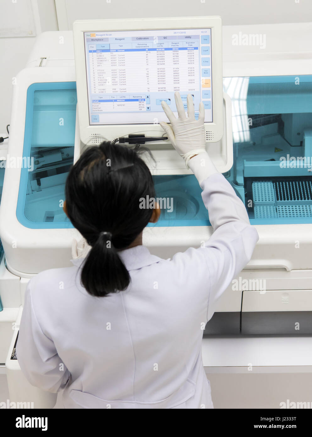 Femme travaillant dans un laboratoire sur une machine moderne pour des tests sanguins. Médecin vérifie le sang des patients. La recherche de sang dans un scientifique moderne wo Banque D'Images