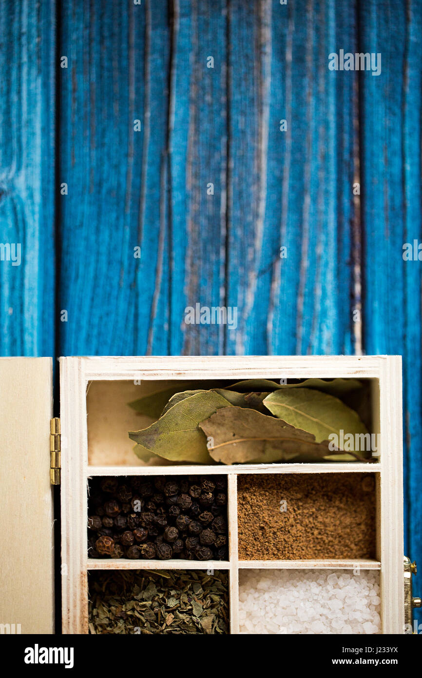 Les épices dans la boîte en bois sur fond bleu. L'espace pour copier du texte et du design. Concept alimentaire. Banque D'Images