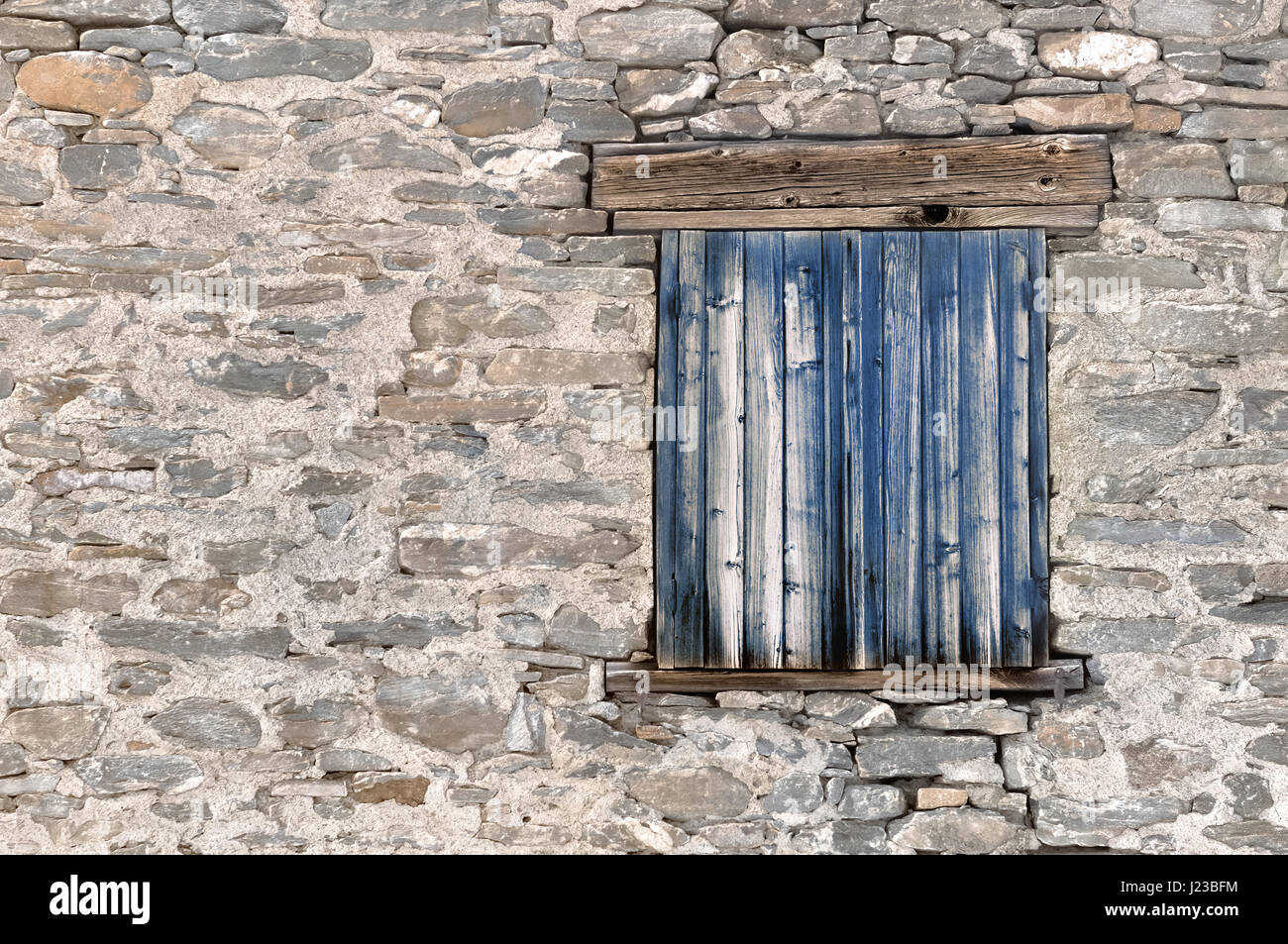 Vieux volets bleus sur une façade en pierre Banque D'Images