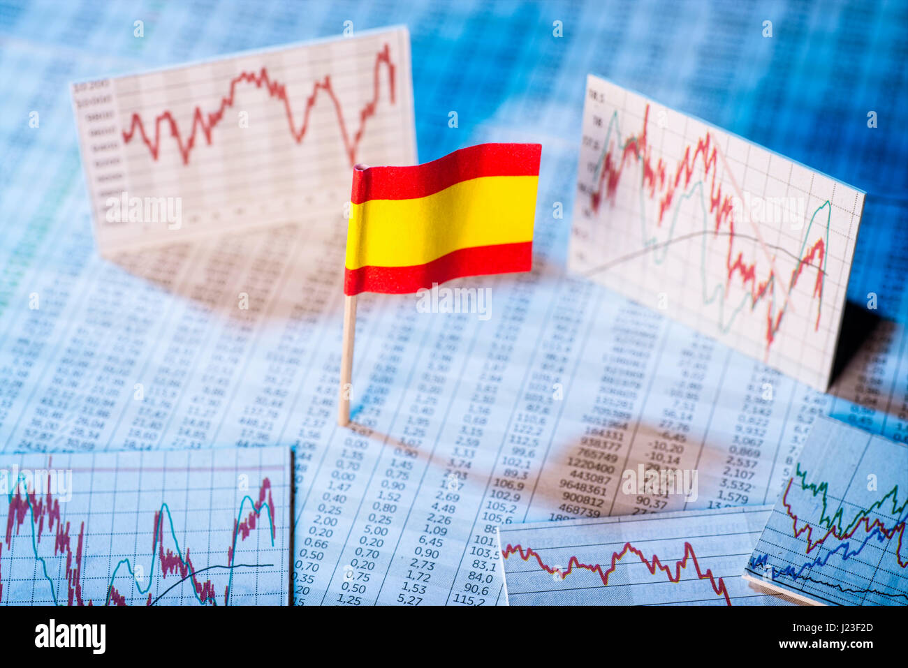 Drapeau espagnol avec des tables de taux et graphiques pour le développement économique. Banque D'Images