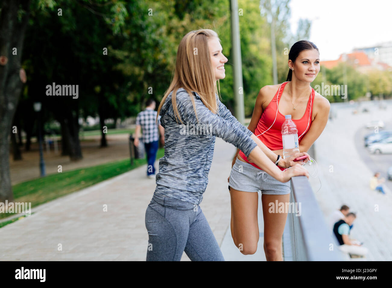 Deux femmes d'étirement et de parler avant que le jogging Banque D'Images