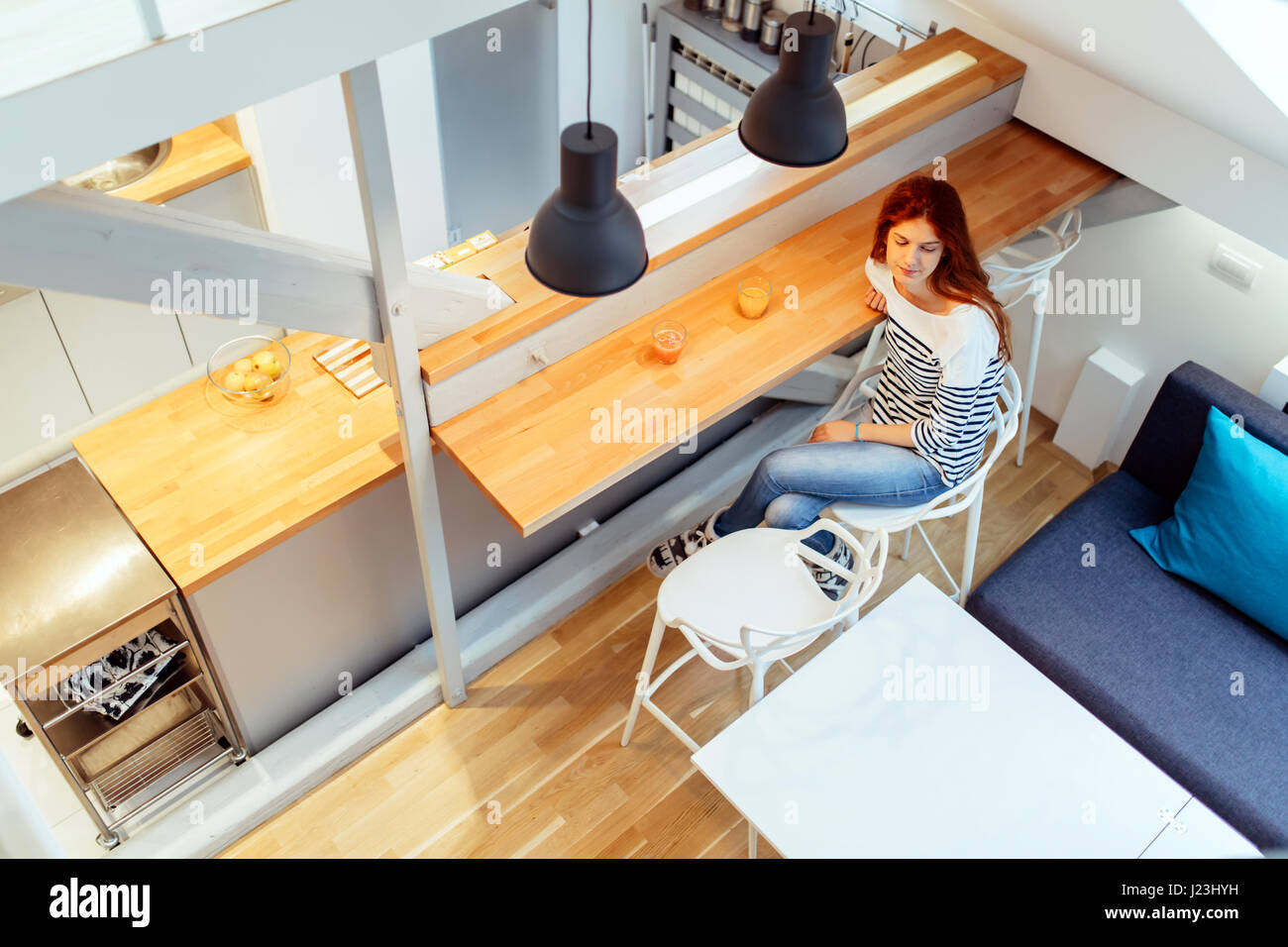 Belle femme assise sur le comptoir dans une maison styslish Banque D'Images