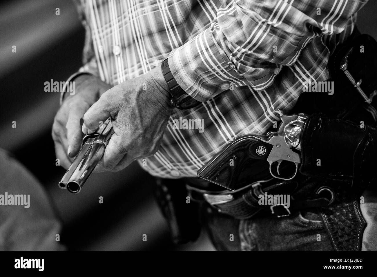 Salado, Texas, USA. Épreuve de tir à cheval cow-boy au Texas. Man rider est le chargement de l'arme avant de la concurrence. Banque D'Images