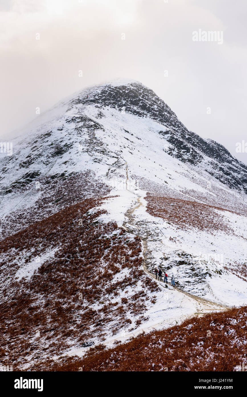 Les marcheurs ont chuté Cat escalade cloches à la fin de l'automne la neige. Parc National de Lake District, Cumbria, Angleterre. Banque D'Images