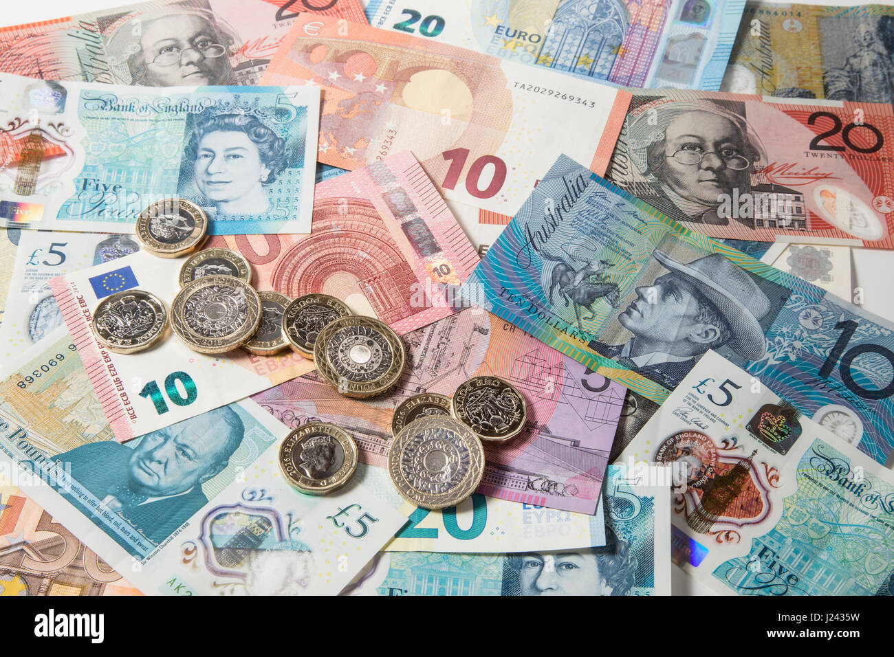 New British £1 et £2 pièces sur un fond d'Euros et £5 pound note Banque D'Images