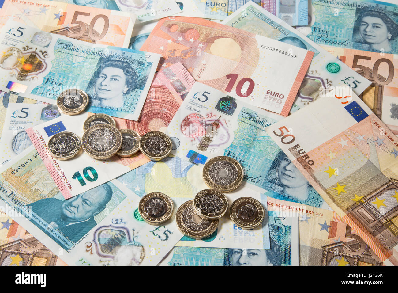 New British £1 et £2 pièces sur un fond d'Euros et £5 pound note Banque D'Images