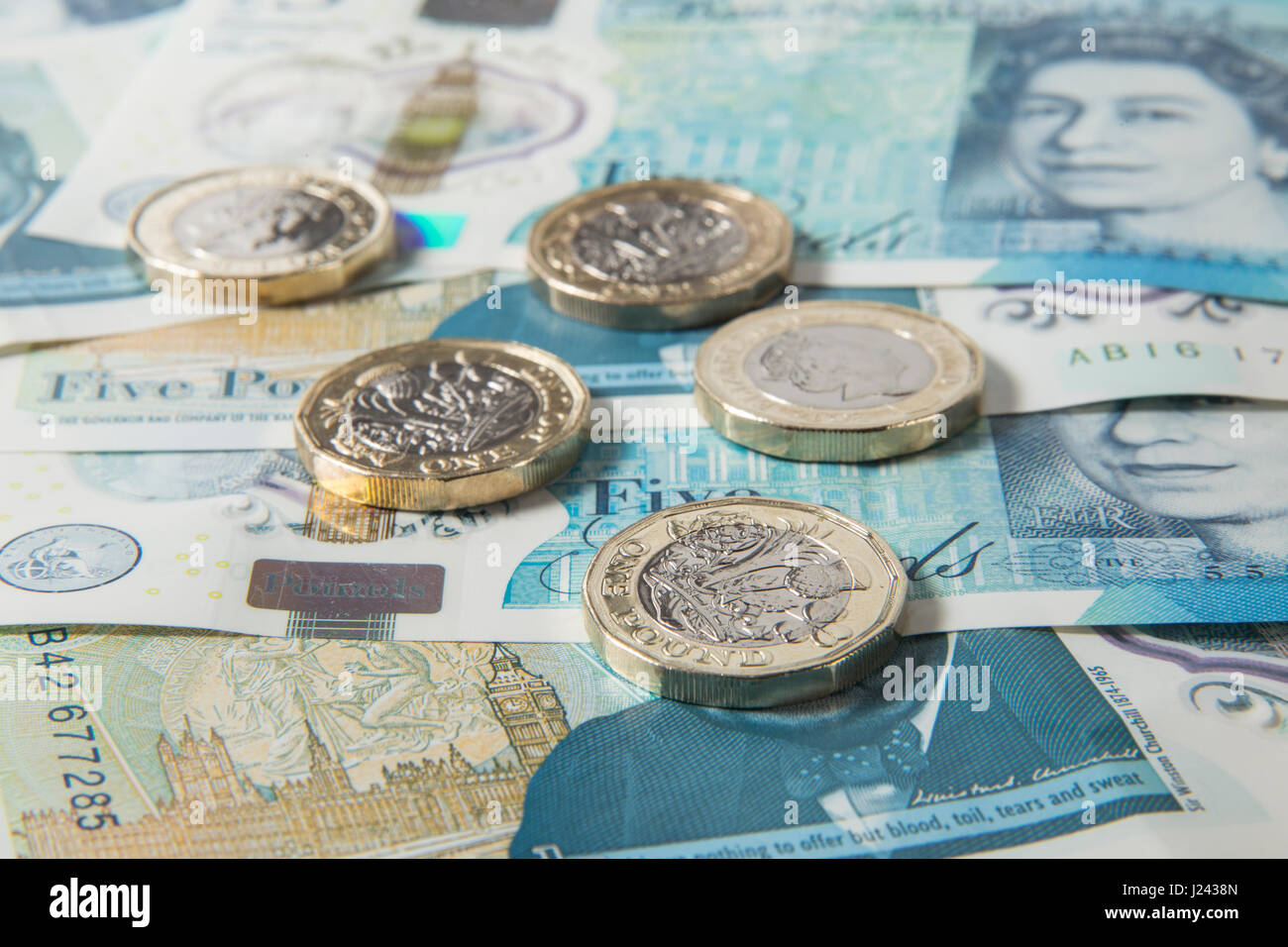 New British €1 pièces sur un fond de UK £5 pound note Banque D'Images