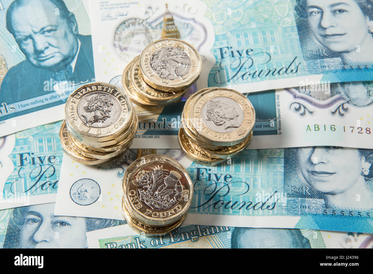 New British €1 pièces sur un fond de UK £5 pound note Banque D'Images