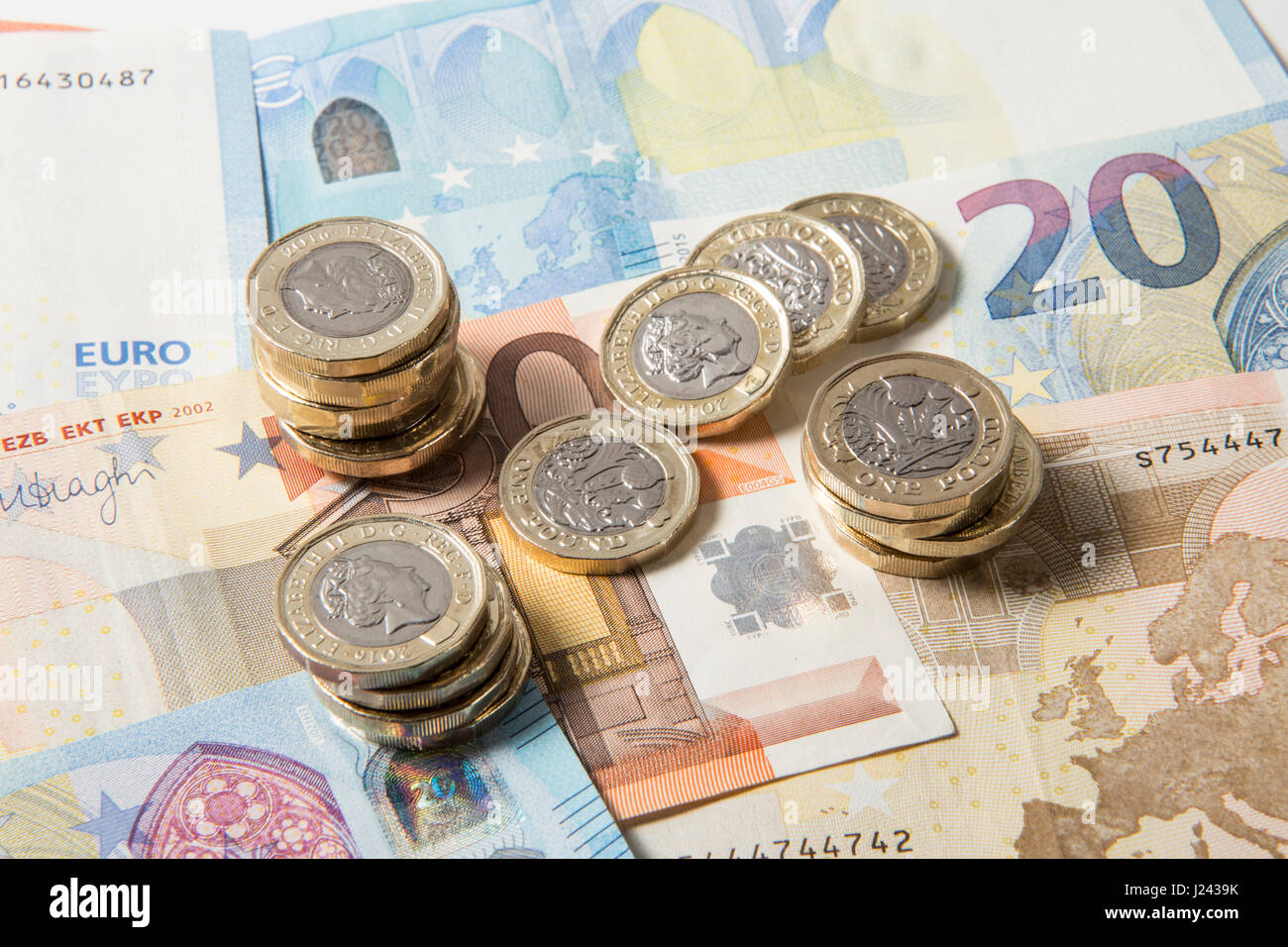 New British €1 pièces sur un fond de UK £5 pound note Banque D'Images