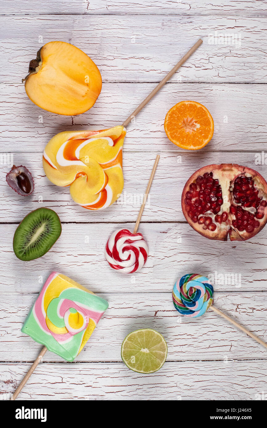 Composition de fruits coupés en deux et lollypops. Conseil en bois blanc Banque D'Images