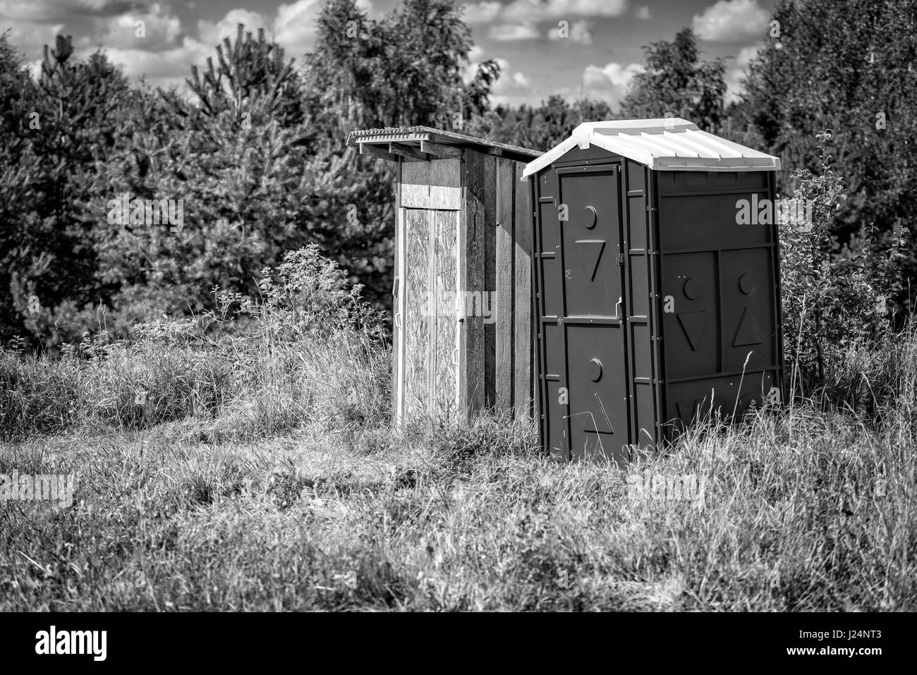 Bord de la forêt est un vieux Toilettes en bois et un nouveau plastique toilettes. Banque D'Images