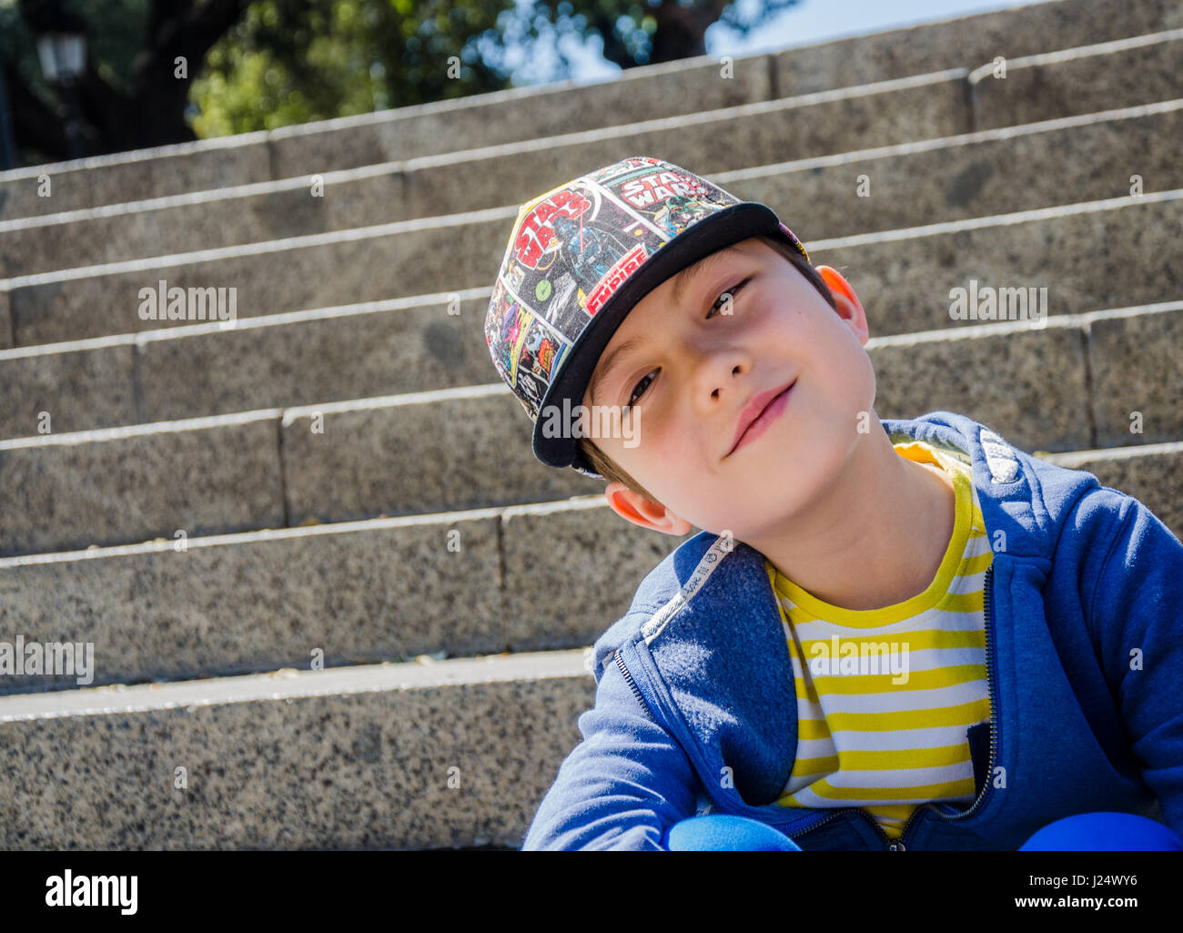 Un jeune garçon portant une casquette pose pour une photo sur les étapes  menant jusqu'à la Plaça de Catalunya, dans le centre de Barcelone Photo  Stock - Alamy