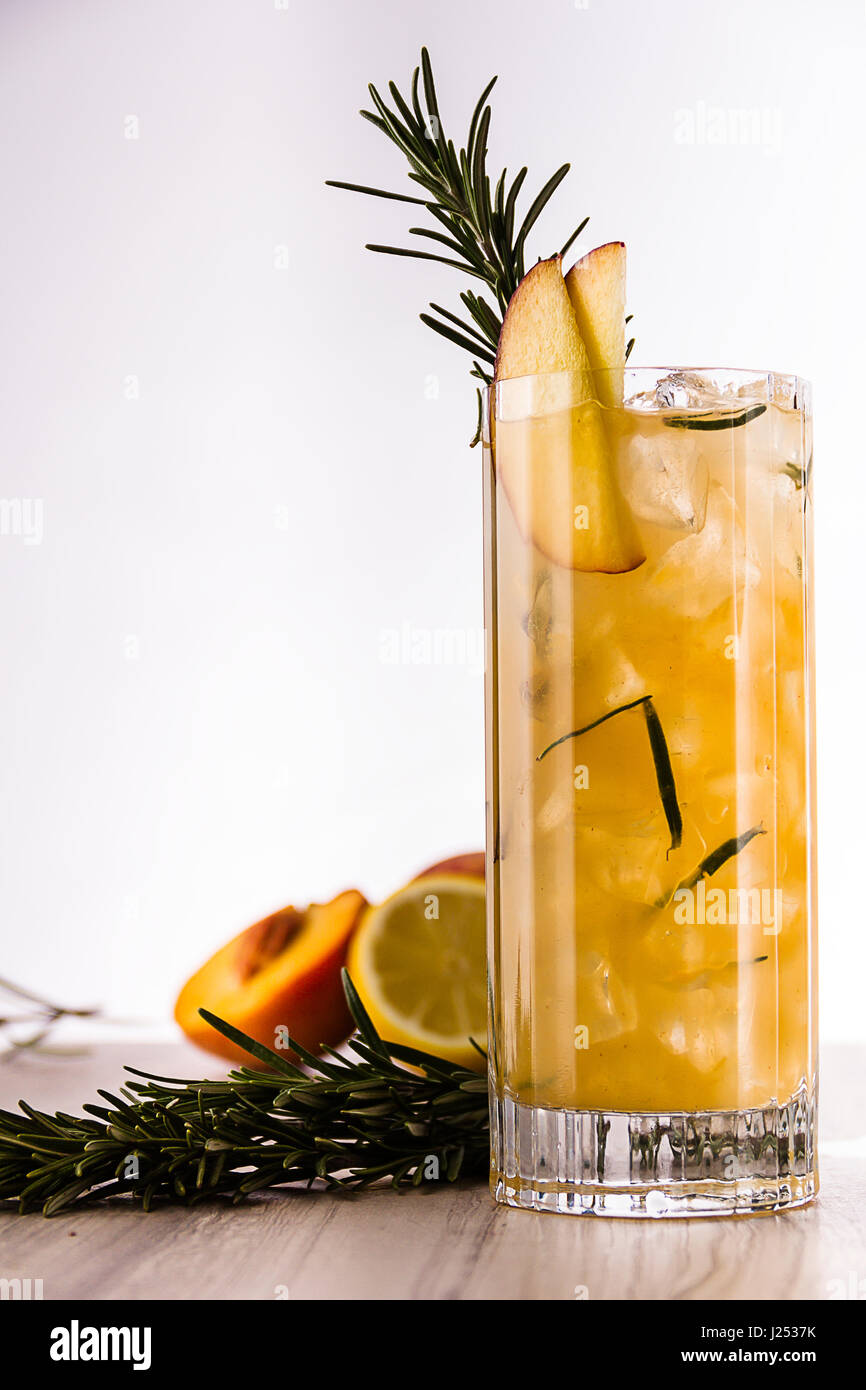 Vodka, liqueur de pêche, du romarin frais, pêches blanches et le jus de  citron. Servi dans un verre d'élingage et garni de pêche fraîche et romarin  Photo Stock - Alamy