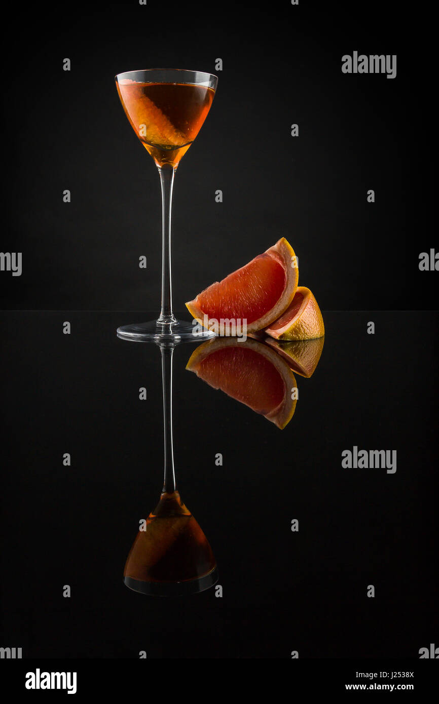 Cognac lentement brassé avec Cocchi Americano, apple et liqueur bitters pamplemousse. Servi dans une petite coupétte et garnie d'un pamplemousse rose Banque D'Images