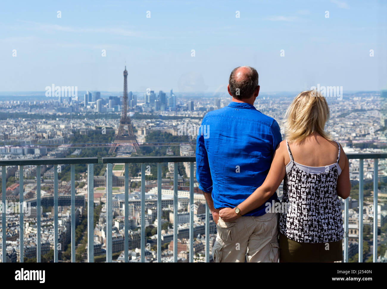 Couple sur la plate-forme d'observation en haut de la Tour Montparnasse, en regardant vers la Tour Eiffel et La Défense, Paris, France Banque D'Images