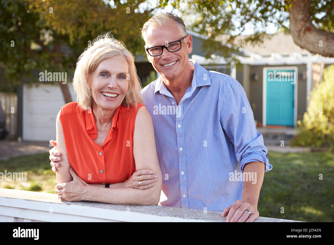 Portrait Of Mature Couple à la clôture plus de cour arrière Banque D'Images