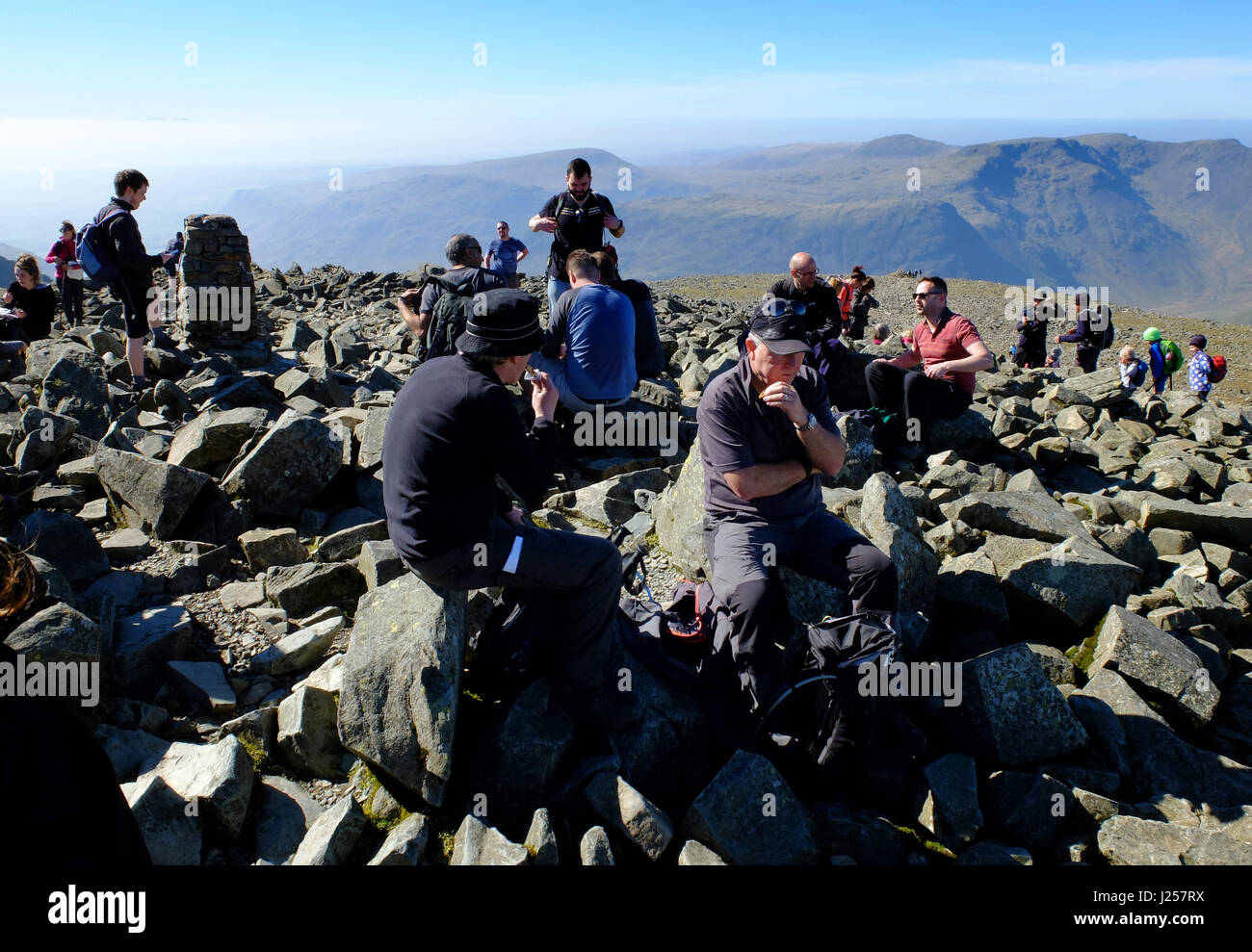 Les randonneurs se détendre au sommet de Scafell Pike, en Angleterre, le plus haut sommet du pays. Banque D'Images
