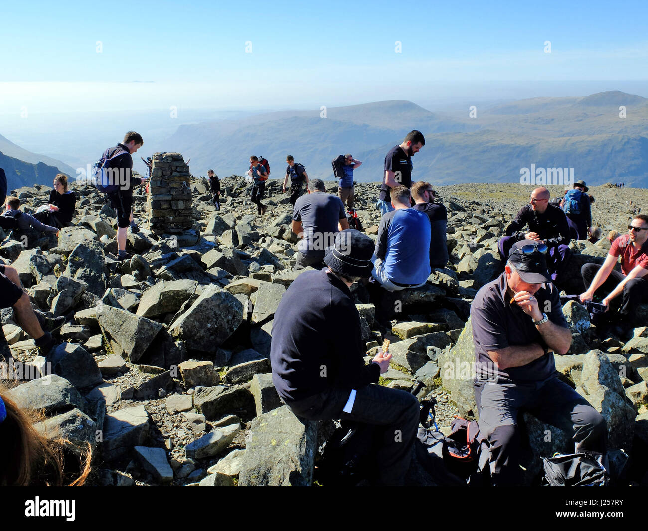 Les randonneurs se détendre au sommet de Scafell Pike, en Angleterre, le plus haut sommet du pays. Banque D'Images