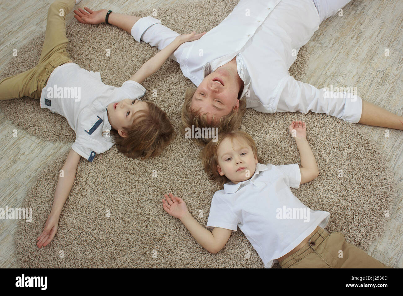 Vue de dessus du jeune père avec mignon fils lying on floor Banque D'Images