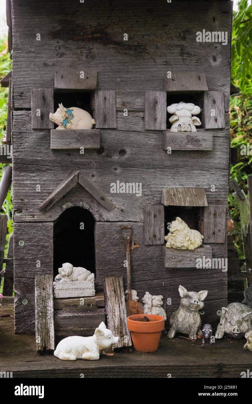 Close-up d'une vieille maison en bois avec des figurines d'animaux de ferme miniature dans un jardin résidentiel paysagé en été Banque D'Images