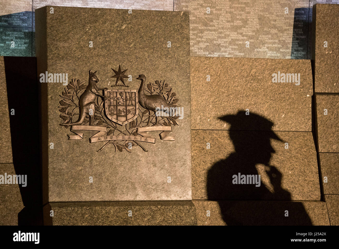 L'ombre d'un soldat tombe sur le Mémorial Australien de la guerre au cours d'un service de l'aube de l'Anzac Day à l'Australian War Memorial à Hyde Park Corner à Londres, marquant l'anniversaire de la première grande action militaire menée par les forces de l'Australie et de la Nouvelle-Zélande au cours de la Première Guerre mondiale. Banque D'Images