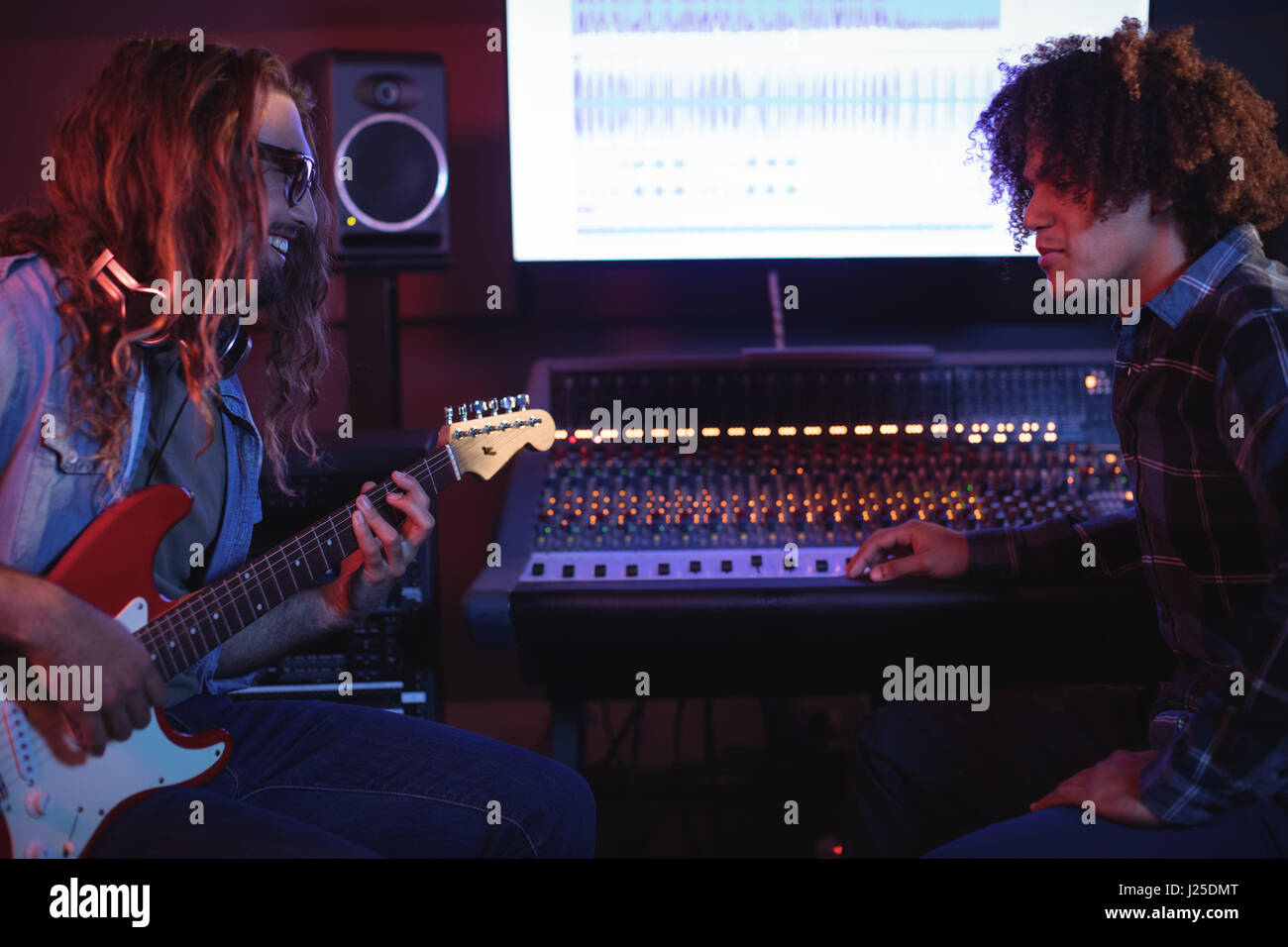 Portrait de femme de l'ingénieur playing electric guitar in recording studio Banque D'Images