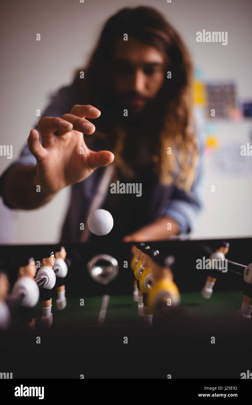 Homme concentré playing table football game Banque D'Images