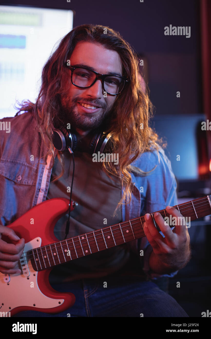 Close-up of male ingénieur du son playing electric guitar en guitare électrique Banque D'Images