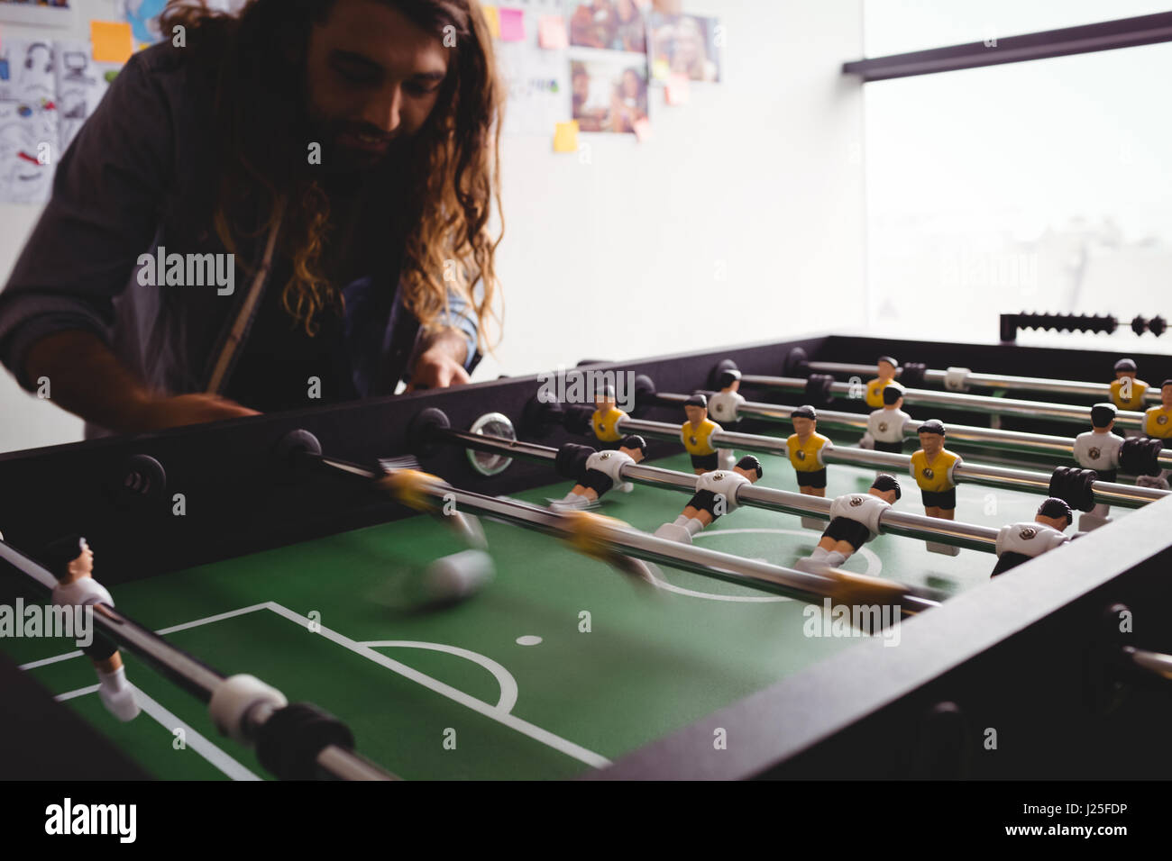 Homme concentré playing table football game Banque D'Images