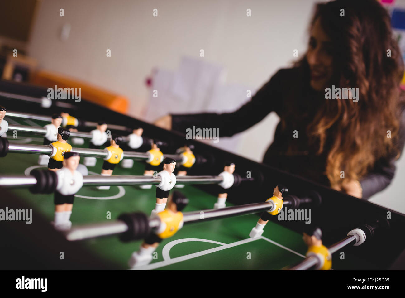 Femme jouant de concentré de match de football de table Banque D'Images