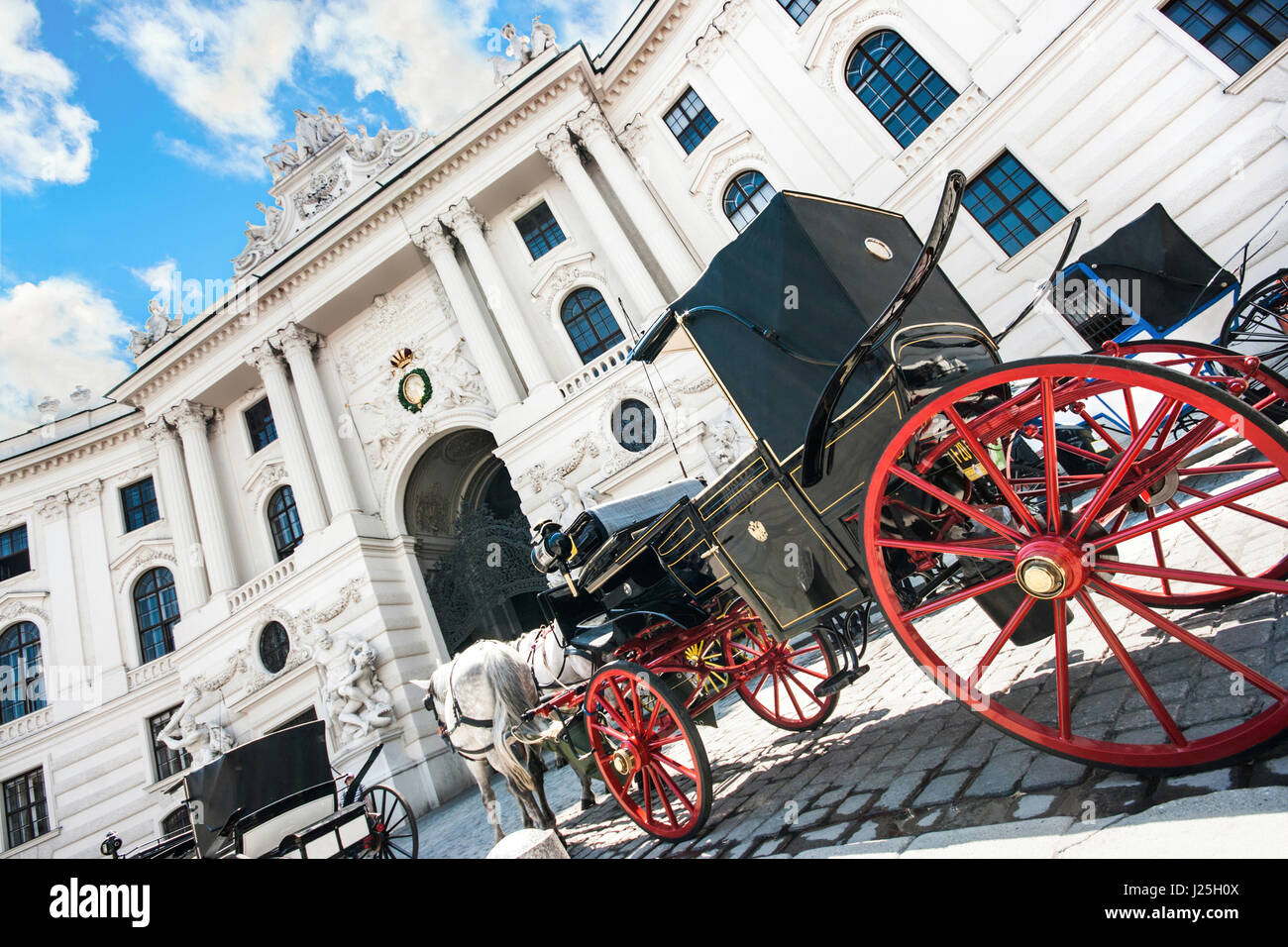 Grand angle de vue du célèbre Palais Hofburg avec des voitures à chevaux Fiaker sur une journée ensoleillée à Vienne, Autriche Banque D'Images