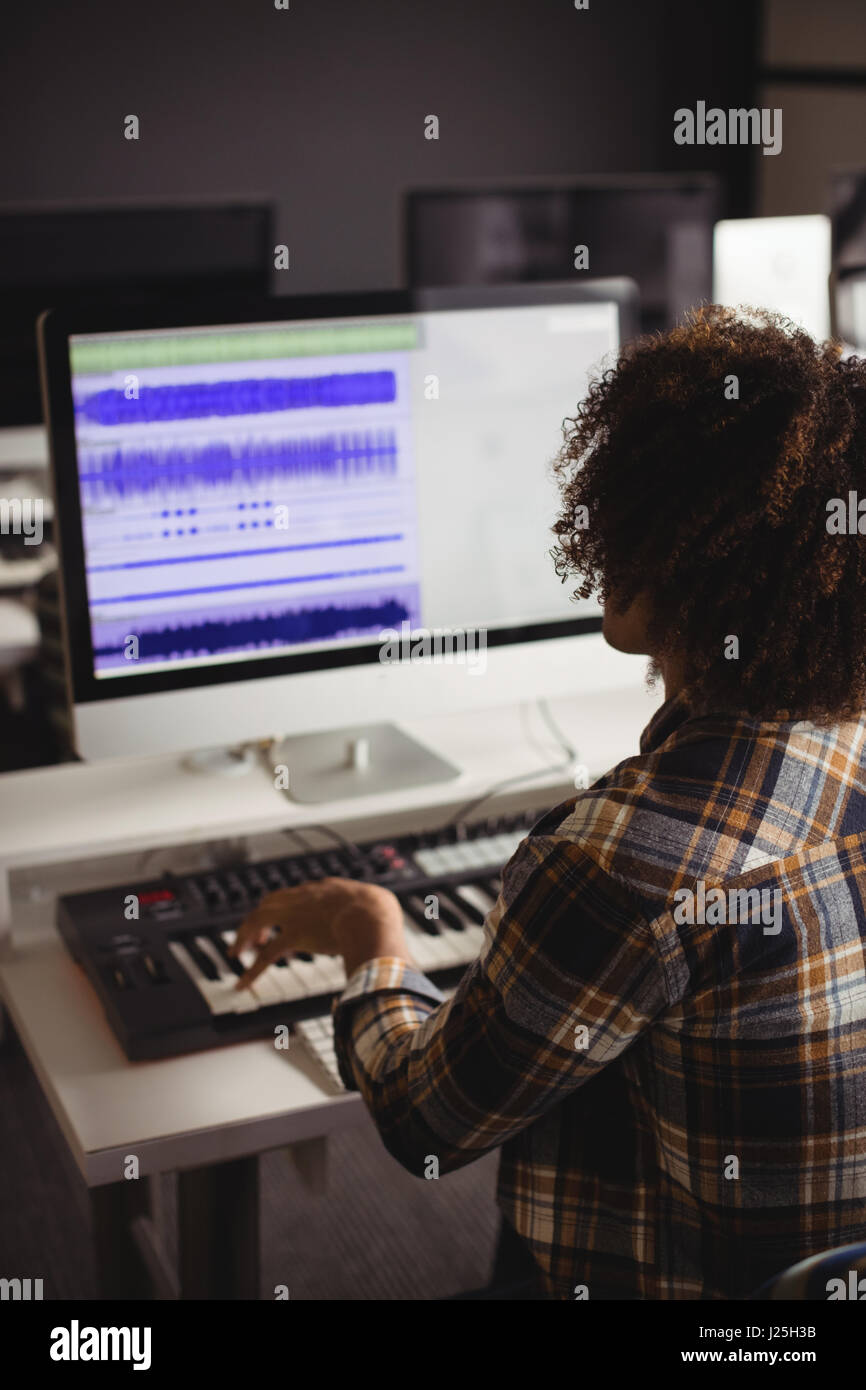 Audio mâle ingénieur travaillant sur écran montage numérique en studio d'enregistrement Banque D'Images