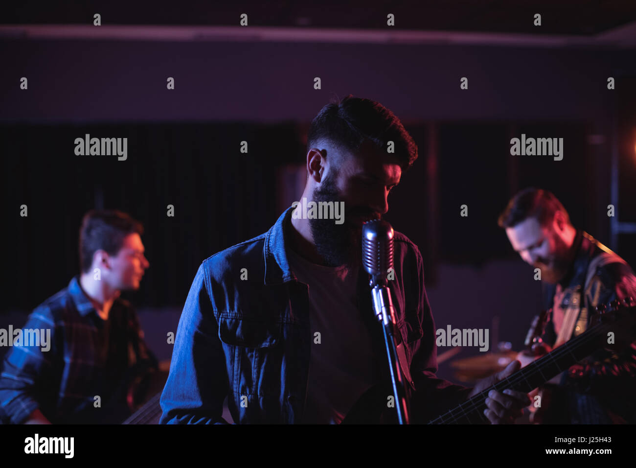 Cose-up du guitariste qui joue de la guitare et chanter dans le studio d'enregistrement Banque D'Images