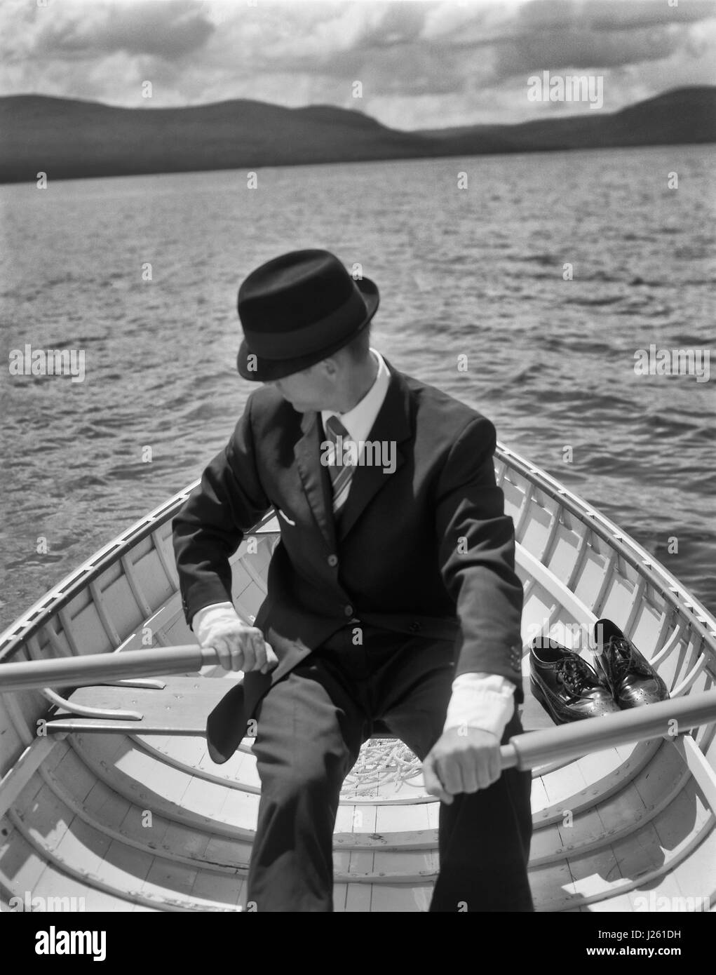 Young Woman Rowing Boat on Lake Banque D'Images