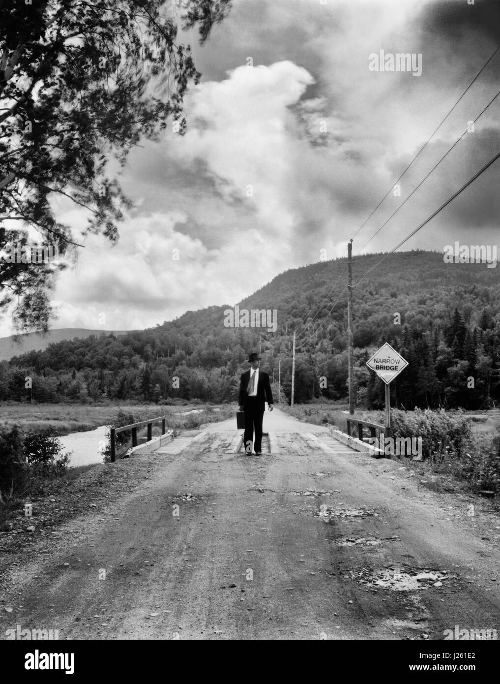 Mid-Adult Woman Walking across rural Narrow Bridge Banque D'Images