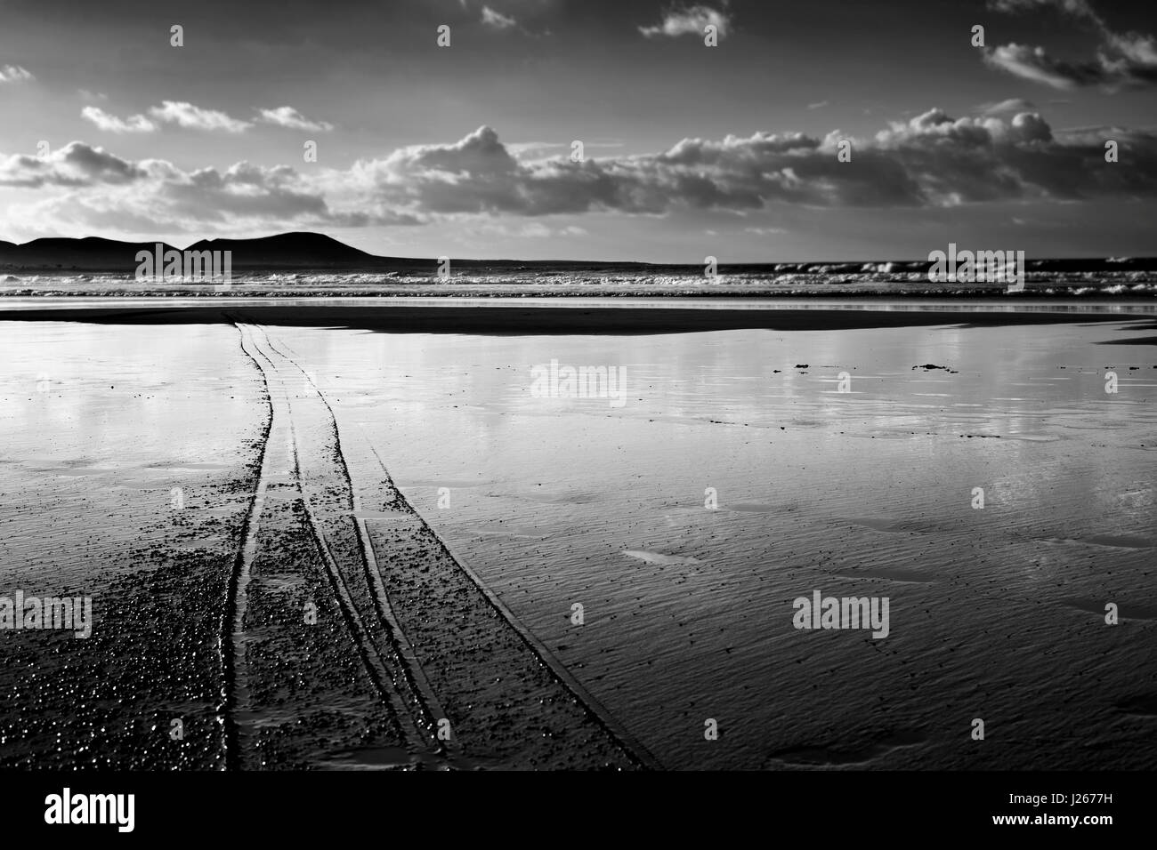 Une vue de la plage de Famara Lanzarote, Canaries, Espagne, avec La Graciosa island dans l'arrière-plan, en noir et blanc Banque D'Images