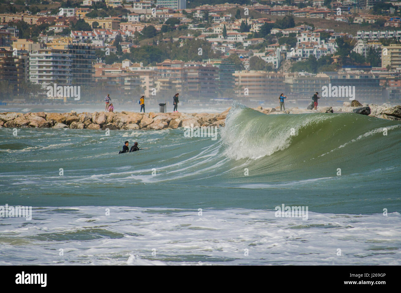 Surfer, surf, surfer tire parti des hautes vagues. Fuengirola, Malaga, Andalousie, Espagne, 2016. Le Code orange est donnée pour de hautes vagues et le vent. Banque D'Images