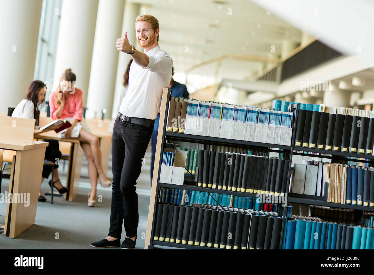 Groupe de jeunes gens qui étudient la lecture et l'éducation elles-mêmes dans la bibliothèque Banque D'Images