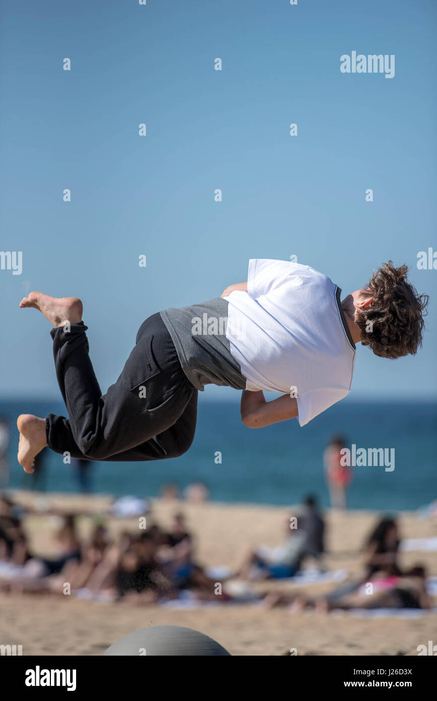 Les enfants sautent très haut sur une plage et faire tourner dans le flip off air sauts acrobatiques Banque D'Images