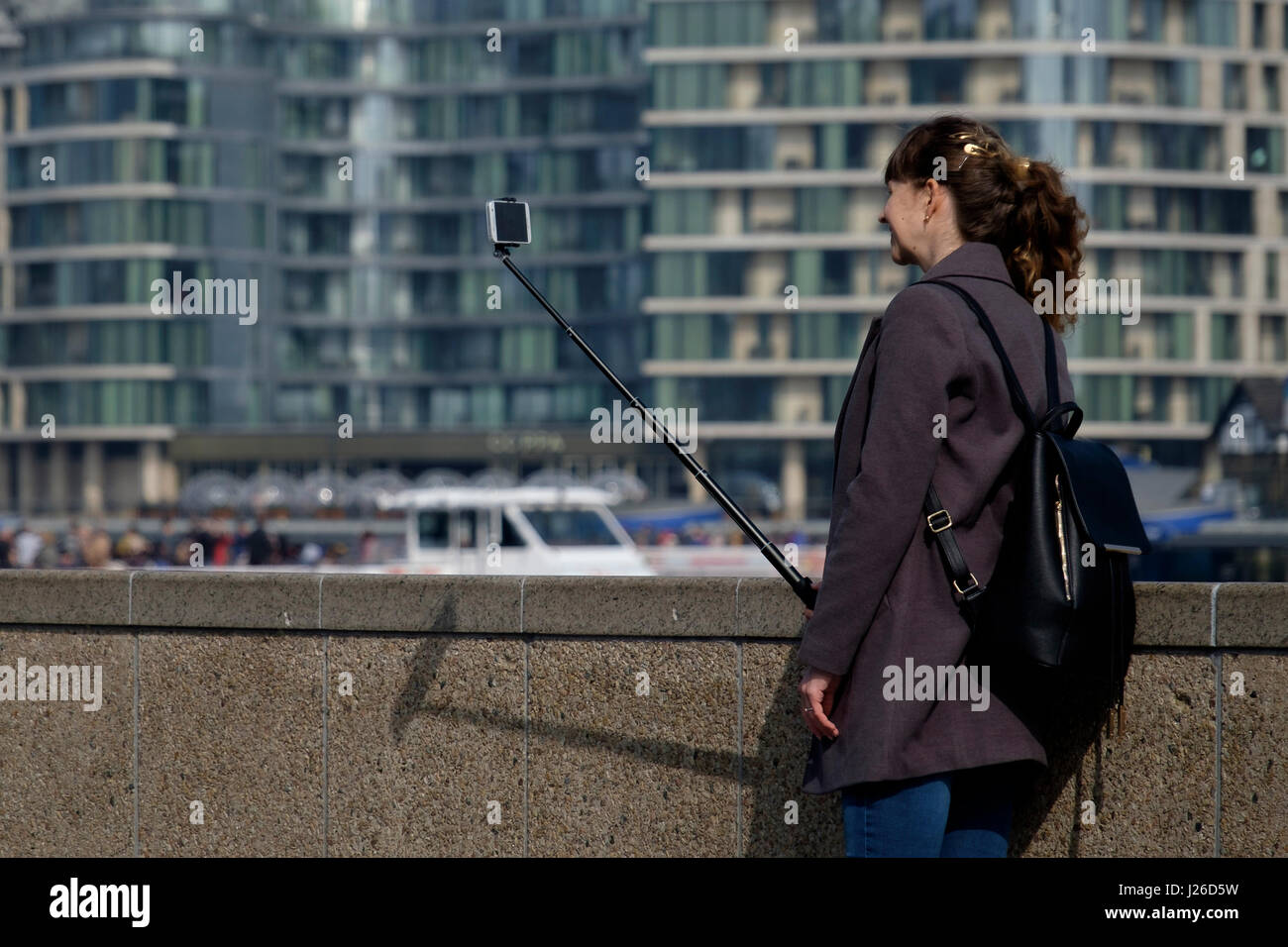 Jeune femme de prendre une photo en utilisant un selfies stick selfies Banque D'Images