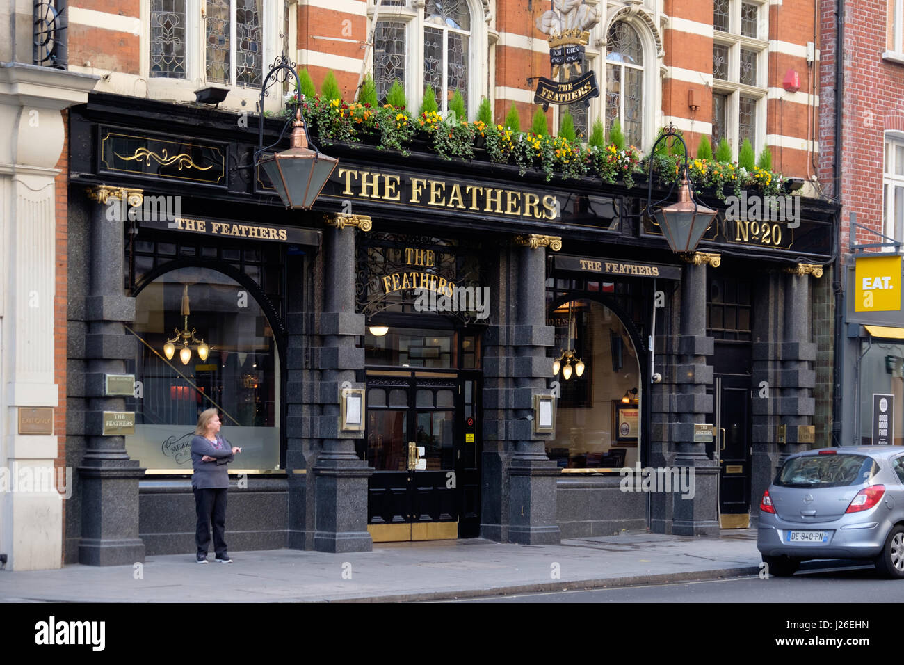 Femme fumer dehors les plumes pub à Londres, Angleterre, Royaume-Uni, Europe Banque D'Images