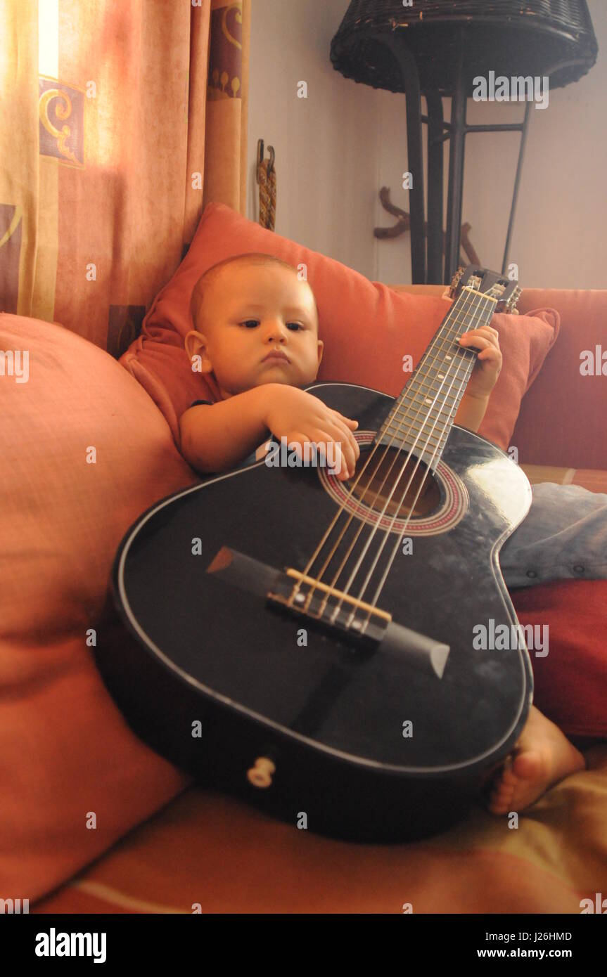Mon fils jouant avec une guitare Banque D'Images