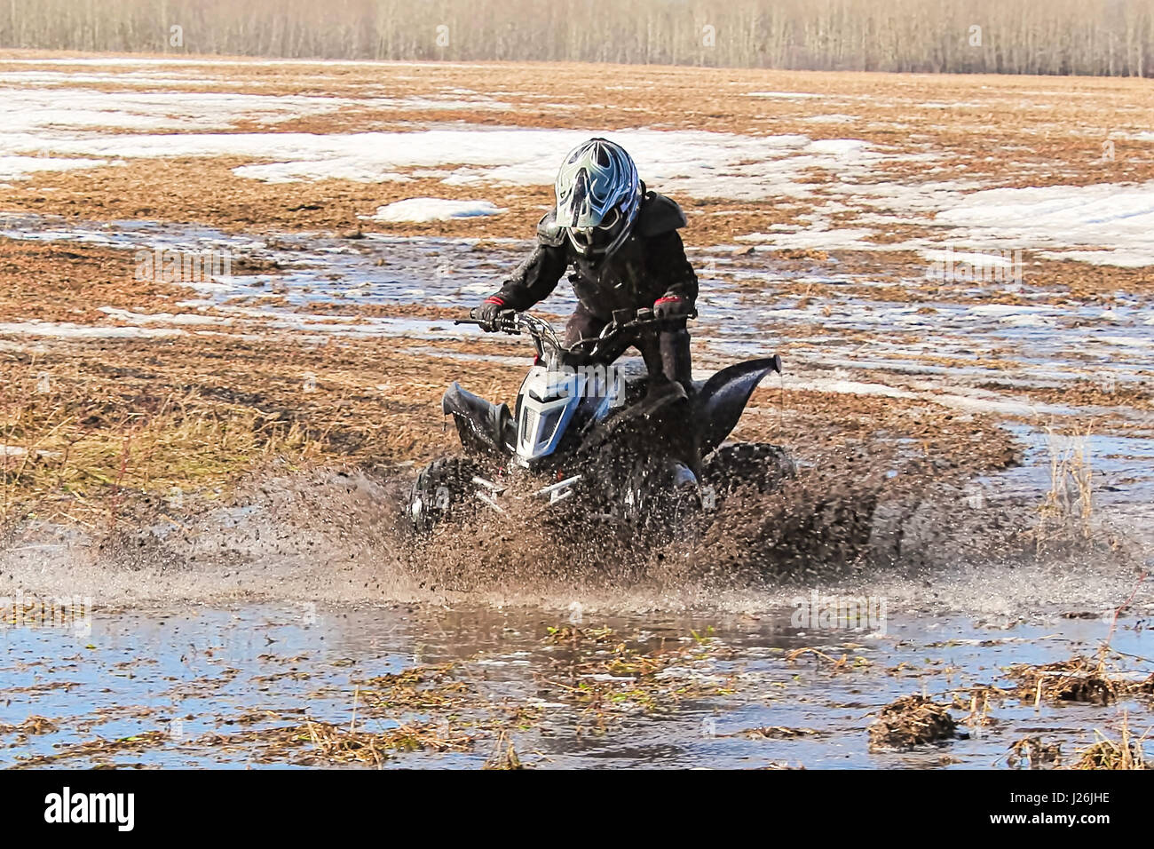 Enfant de la création d'un grand splash avec son quad. Banque D'Images Enfant de la création d'un grand splash avec son quad. Banque D'Images