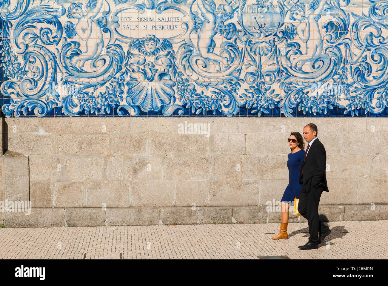 Portugal carreaux Porto, vue d'un couple portugais passant devant l'église Igreja do Carmo dont le mur est richement décoré dans des tuiles bleues azulejos, Porto Banque D'Images