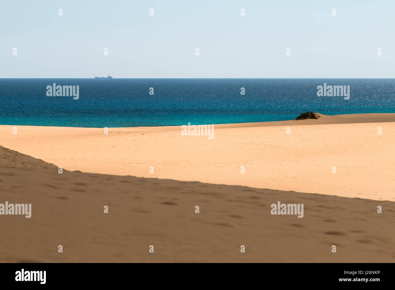 Vue sur la célèbre les dunes de sable de Corralejo à Fuerteventura, Espagne sur la plage avec ciel bleu et d'un navire à l'arrière-plan. Banque D'Images