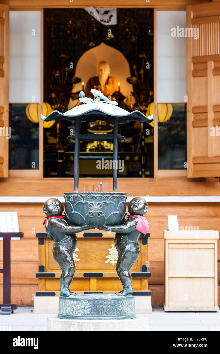 Le Japon, Kobe, Suma dera. Brûleur en extérieur hall avec statue de Bouddha. L'accent sur le brûleur d'encens. Banque D'Images
